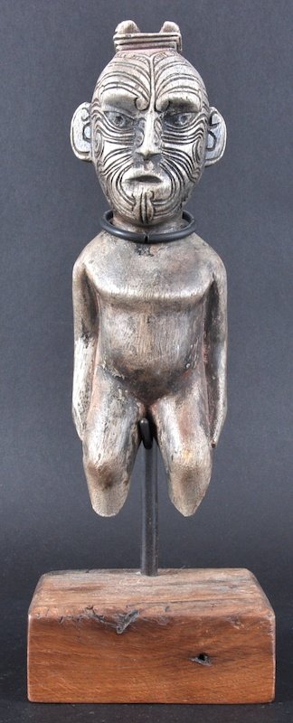A FINE EARLY 20TH CENTURY CARVED WOOD MAORI FIGU: A FINE EARLY 20TH CENTURY CARVED WOOD MAORI FIGURE the seated tiki with well carved features and intricate motifs to the face, supported upon an early oak block. Figure 9. 5ins high. Note: It is belie