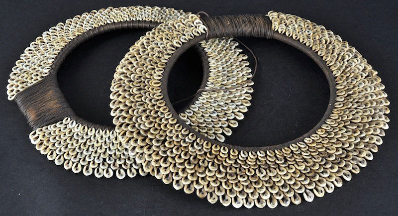 A PAIR OF EARLY 20TH CENTURY NEW GUINEA SHELL NEC: A PAIR OF EARLY 20TH CENTURY NEW GUINEA SHELL NECK DECORATIONS with material mounts. 11ins diameter.
