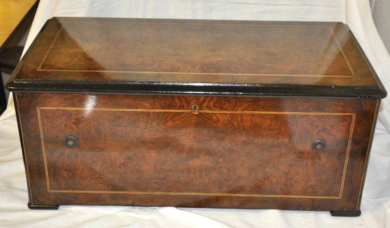 A SUPERB SWISS MUSICAL BOX in a walnut case playi: A SUPERB SWISS MUSICAL BOX in a walnut case playing eight airs with bells and drums. 22ins long.