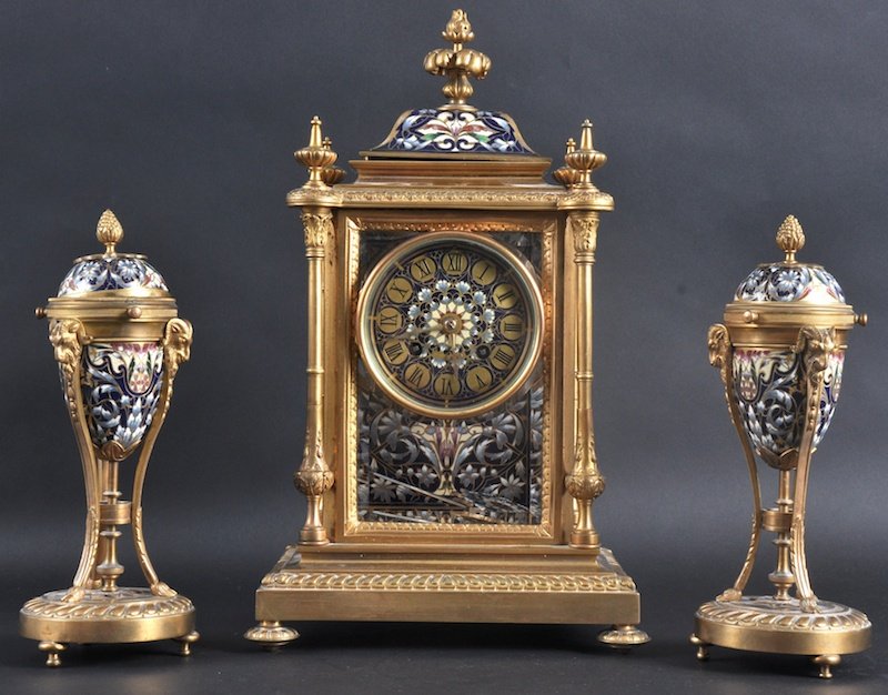 A LOVELY 19TH CENTURY FRENCH ORMOLU AND CHAMPLEVE: A LOVELY 19TH CENTURY FRENCH ORMOLU AND CHAMPLEVE ENAMEL CLOCK GARNITURE decorated with foliage with acanthus capped pillars. Clock 14ins high.