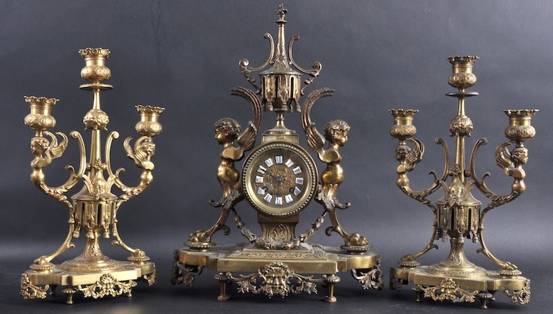 A 19TH CENTURY FRENCH BRONZE CLOCK GARNITURE for: A 19TH CENTURY FRENCH BRONZE CLOCK GARNITURE formed with caryatid mounts, upon a shaped base, the dial inset with blue enamel numerals. Clock 16ins high.