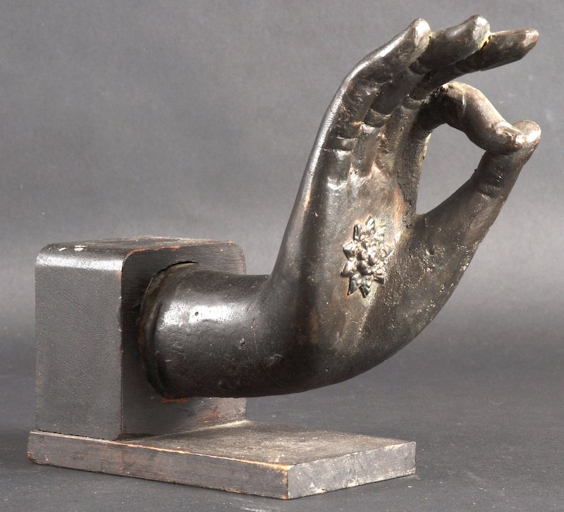 AN 18TH CENTURY SOUTH EAST ASIAN BRONZE BUDDHAS H: AN 18TH CENTURY SOUTH EAST ASIAN BRONZE BUDDHAS HAND upon an ebonised base. 7. 5ins wide.