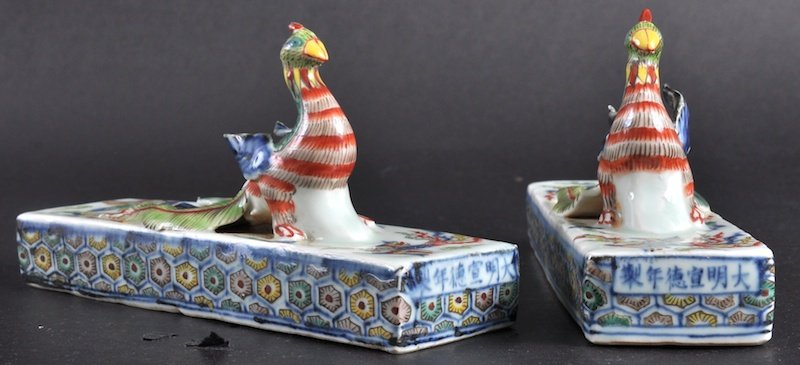 A RARE AND UNUSUAL PAIR OF EARLY 20TH CENTURY CHIN: A RARE AND UNUSUAL PAIR OF EARLY 20TH CENTURY CHINESE PORCELAIN WUCAI SCROLL WEIGHTS bearing Xuande marks to the front, formed as a seated bird upon a rectangular base enamelled with birds. Minor frit