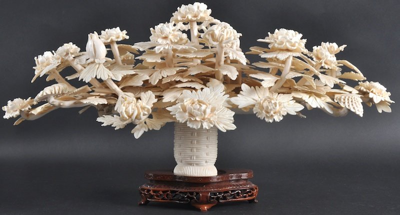AN UNUSUAL LARGE EARLY 20TH CENTURY CHINESE IVORY: AN UNUSUAL LARGE EARLY 20TH CENTURY CHINESE IVORY FLOWER BASKET well carved with emerging foliage and budding flowers, upon a later hardwood base. Few faults. Ivory 1ft 8ins wide.