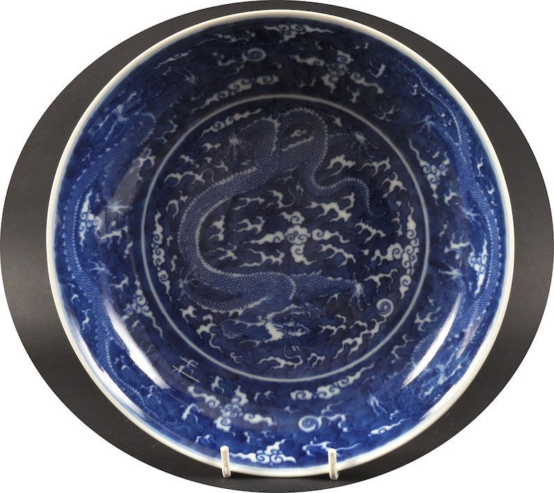 A CHINESE BLUE AND WHITE CIRCULAR DRAGON DISH bea: A CHINESE BLUE AND WHITE CIRCULAR DRAGON DISH bearing Qianlong marks to base, painted amongst crashing waves. Glaze flaw to base.8.75ins diameter.