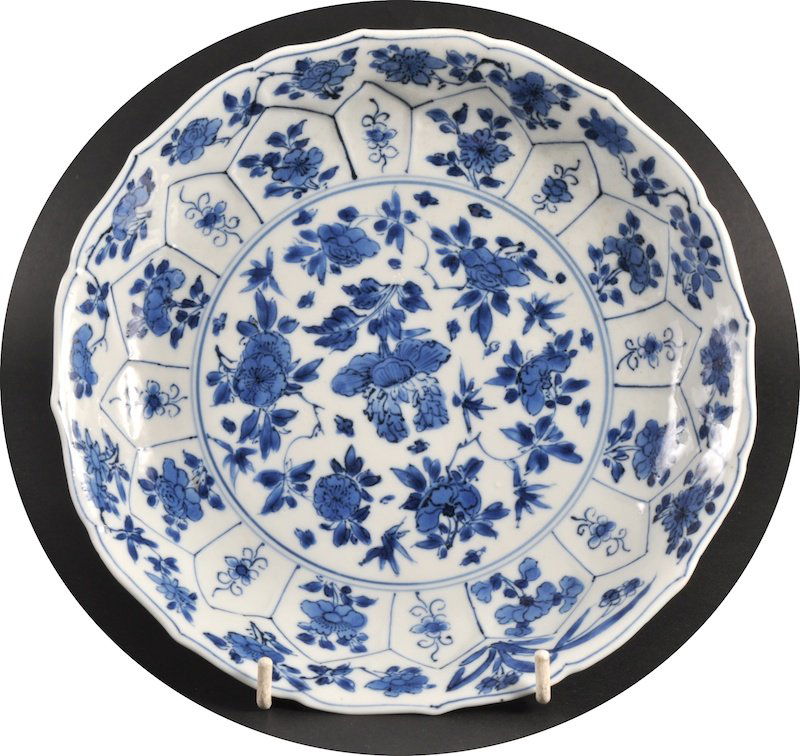 A 17TH CENTURY CHINESE BLUE AND WHITE SCALLOPED P: A 17TH CENTURY CHINESE BLUE AND WHITE SCALLOPED PLATE Kangxi mark and period, painted with foliage. Minor fritting.8.25ins diameter.