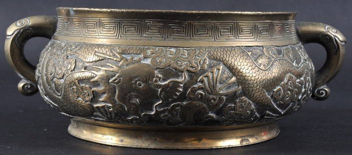 A GOOD 19TH CENTURY CHINESE BRONZE TWIN HANDLED C: A GOOD 19TH CENTURY CHINESE BRONZE TWIN HANDLED CENSER bearing Xuande marks to base, decorated in relief with five claw dragons. Minor wear, rim dinks. 8ins wide.