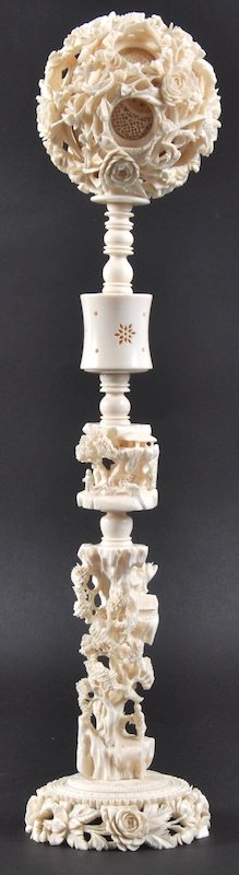 A LATE 19TH CENTURY CHINESE CANTON IVORY PUZZLE B: A LATE 19TH CENTURY CHINESE CANTON IVORY PUZZLE BALL ON STAND carved with landscapes and buildings, upon a foliate carved base. Good condition.13.75ins high.