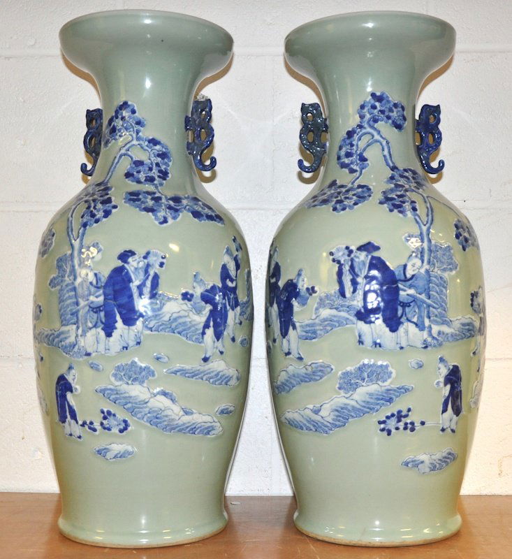 A PAIR OF 19TH CENTURY CHINESE BLUE AND WHITE CELA: A PAIR OF 19TH CENTURY CHINESE BLUE AND WHITE CELADON VASES decorated with figures standing within a rocky garden. One with repair and chips to rim. 2ft high.