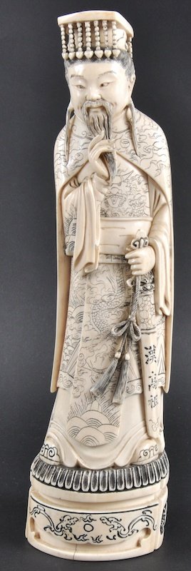 A CHINESE CARVED IVORY LATE QING DYNASTY IVORY FIG: A CHINESE CARVED IVORY LATE QING DYNASTY IVORY FIGURE bearing Qianlong marks to base, incised with dragons. Good condition. 12ins high.
