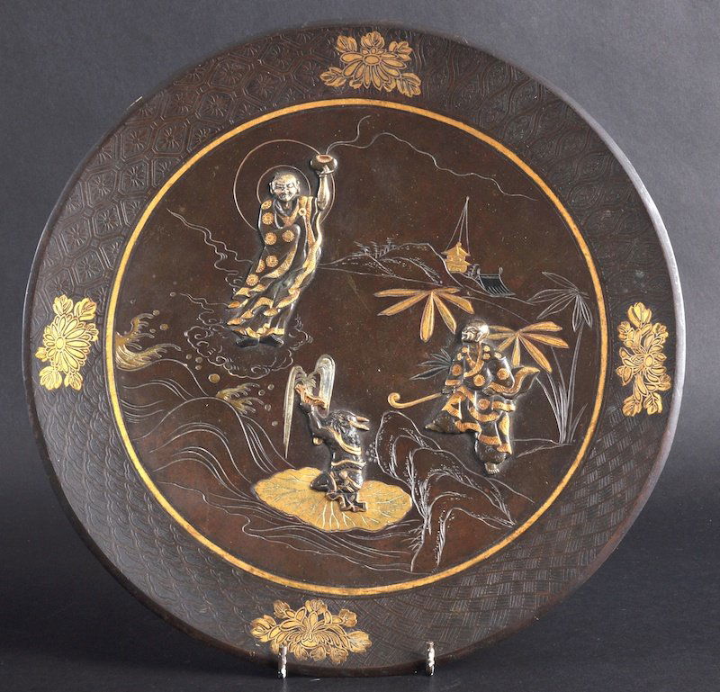 A LATE 19TH CENTURY JAPANESE MEIJI PERIOD BRONZE P: A LATE 19TH CENTURY JAPANESE MEIJI PERIOD BRONZE PLAQUE decorated in relief with two figures worshipping a Buddhist male. Signed. Good condition. 11. 75ins diameter.