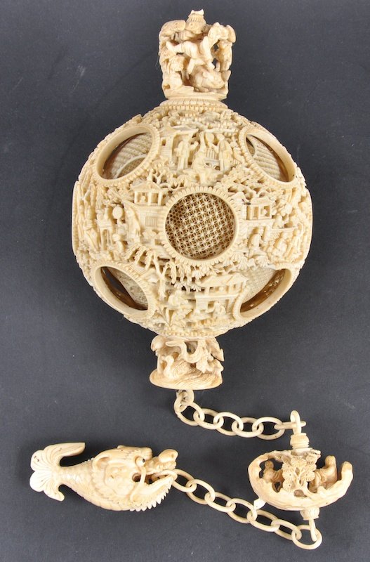 A FINE CHINESE QING DYNASTY CANTON IVORY PUZZLE BA: A FINE CHINESE QING DYNASTY CANTON IVORY PUZZLE BALL LANTERN unusually complete fish hanging fish terminal and decorated with figures within landscapes in various pursuits. Small loss to one outer sec