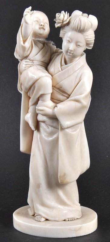 A LOVELY LATE 19TH CENTURY JAPANESE MEIJI PERIOD I: A LOVELY LATE 19TH CENTURY JAPANESE MEIJI PERIOD IVORY OKIMONO depicting a standing geisha holding aloft a young child. Signed. Good condition. 6. 5ins high.