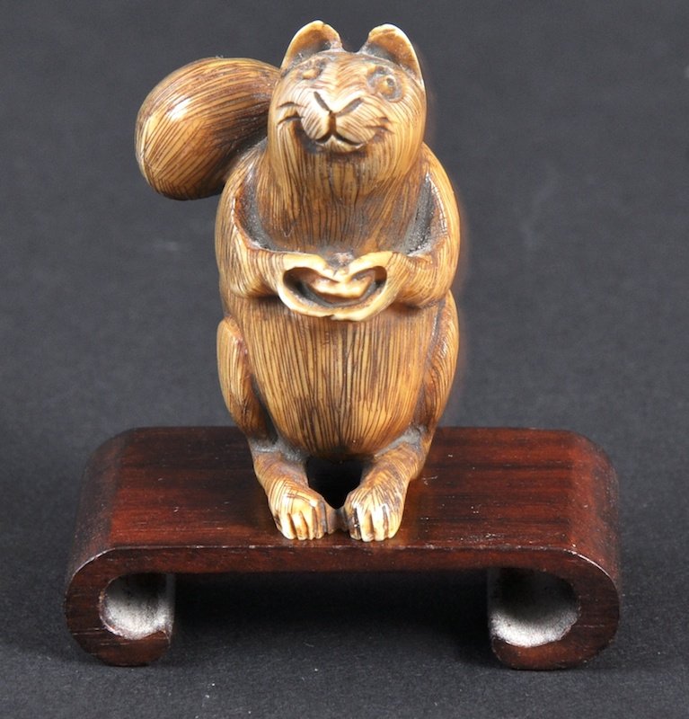 A CARVED IVORY NETSUKE OF A SQUIRREL. : A CARVED IVORY NETSUKE OF A SQUIRREL.
