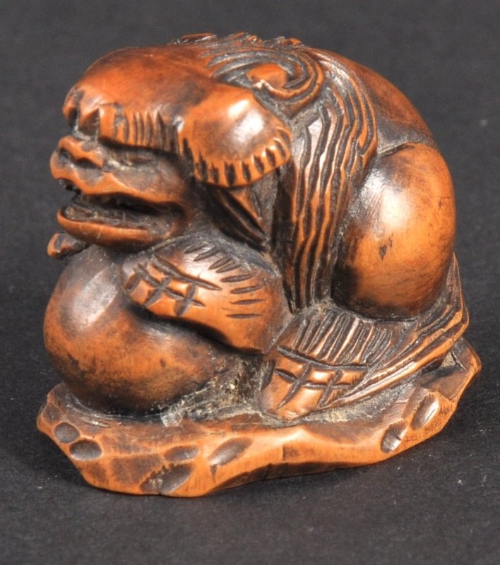 A CARVED IVORY NETSUKE OF A DOG OF FOE. : A CARVED IVORY NETSUKE OF A DOG OF FOE.