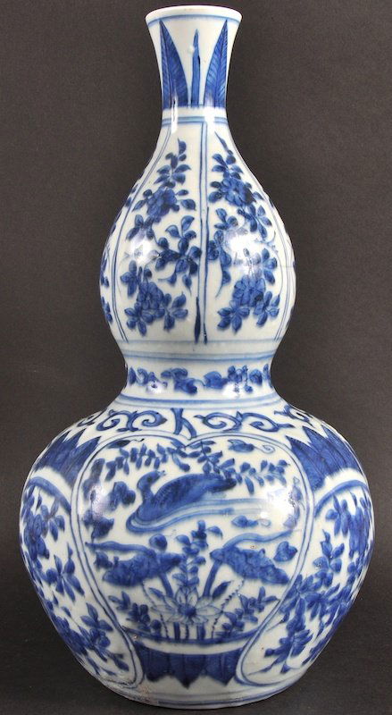 A 16TH CENTURY CHINESE PORCELAIN BLUE AND WHITE DOUBLE: A 16TH CENTURY CHINESE PORCELAIN BLUE AND WHITE DOUBLE GOURD VASE Wanli, painted with panels of birds and foliage. 12. 5ins high.