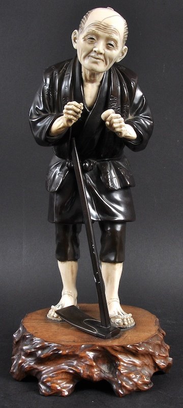 A GOOD 19TH CENTURY JAPANESE BRONZE AND IVORY FIGURE OF: A GOOD 19TH CENTURY JAPANESE BRONZE AND IVORY FIGURE OF A FARMER modelled upon a hardwood base. Good condition. Signed. Bronze 11.25ins high.