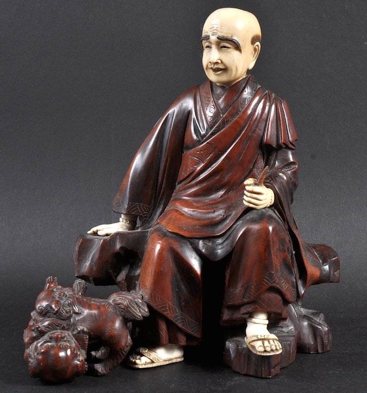 A LATE 19TH CENTURY JAPANESE MEIJI PERIOD IVORY AND CAR: A LATE 19TH CENTURY JAPANESE MEIJI PERIOD IVORY AND CARVED WOOD FIGURE depicting a seated male scholar with fighting kylin beneath him. Signed. Minor faults. 8.5ins high.