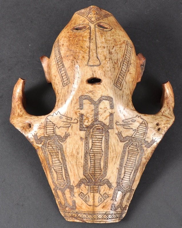 AN EARLY 20TH CENTURY BORNEO DAYAK TRIBE HUNTING TROPHY: AN EARLY 20TH CENTURY BORNEO DAYAK TRIBE HUNTING TROPHY the animal skull carved with myhtical figures. 9ins long.