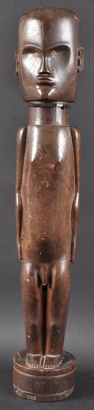 AN EARLY 20TH CENTURY SUDANESE CARVED WOOD FIGURE OF A : AN EARLY 20TH CENTURY SUDANESE CARVED WOOD FIGURE OF A MALE modelled standing upon a circular plinth. 2ft 1ins high.