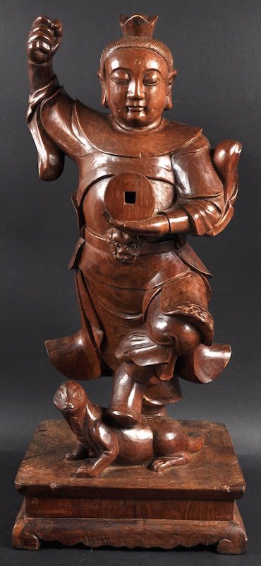 A LARGE CHINESE LATE QING CARVED WOOD FIGURE OF A STAND: A LARGE CHINESE LATE QING CARVED WOOD FIGURE OF A STANDING WARRIOR modelled with one foot upon a recumbent beast. Minor faults. 2ft 2.5ins high.