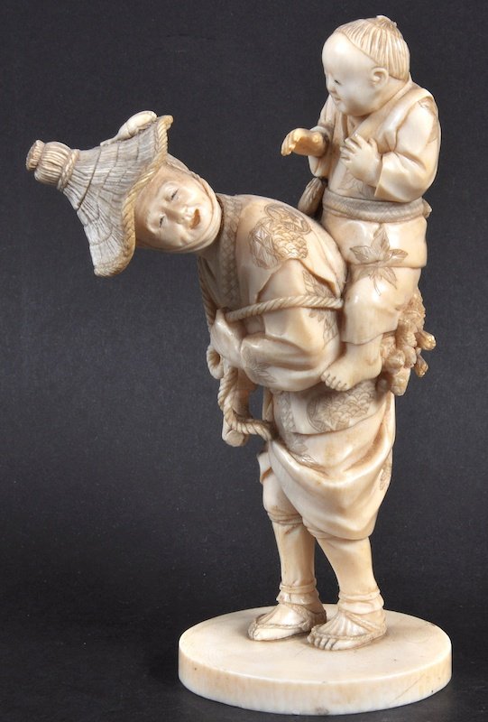 A 19TH CENTURY JAPANESE MEIJI PERIOD IVORY OKIMONO mode: A 19TH CENTURY JAPANESE MEIJI PERIOD IVORY OKIMONO modelled as a father with a young children leaning upon his back. Small loss. Signed. 6.5ins high.