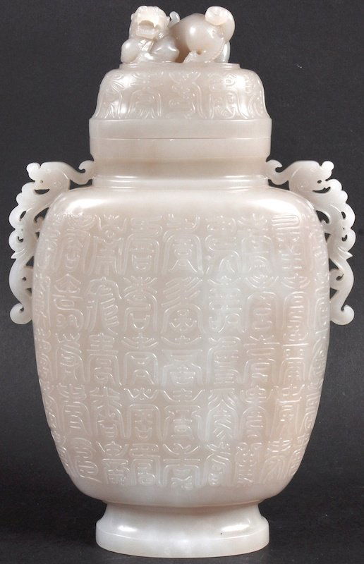 A GOOD EARLY 20TH CENTURY CHINESE TWIN HANDLED WHITE JA: A GOOD EARLY 20TH CENTURY CHINESE TWIN HANDLED WHITE JADE VASE AND COVER with kylin handles, the body smothered to both sides with calligraphy. Good condition. 8.75ins high.