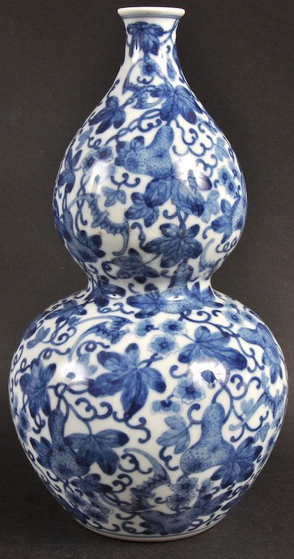 A CHINESE BLUE AND WHITE DOUBLE GOURD VASE bearing Yong: A CHINESE BLUE AND WHITE DOUBLE GOURD VASE bearing Yongzheng marks to base, painted with flowering grape leaf. Good condition. 11.75ins high.