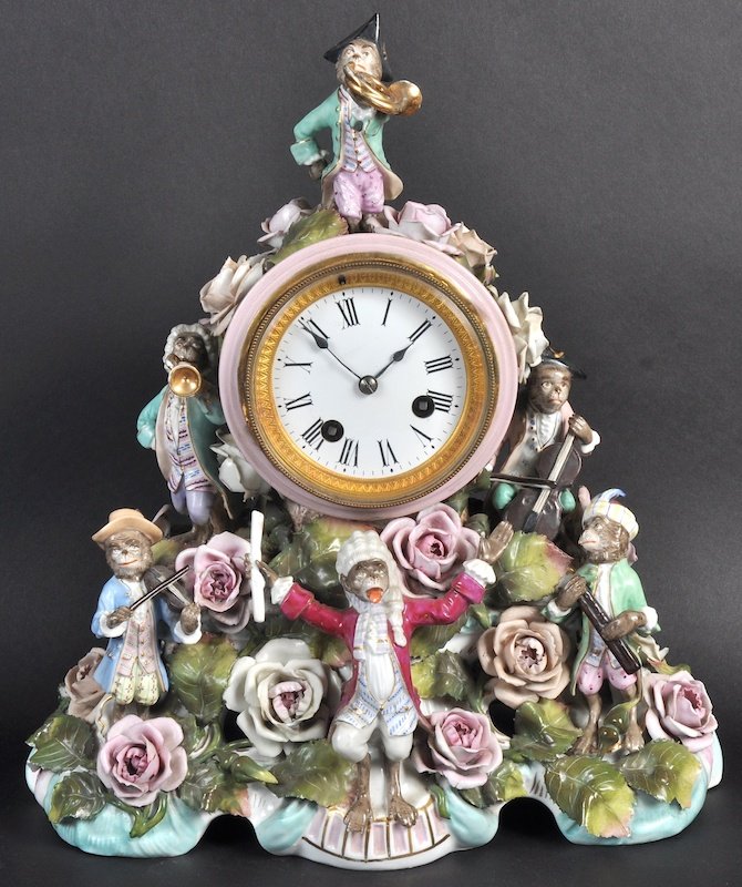 A GOOD 19TH CENTURY GERMAN PORCELAIN MANTLE CLOCK with: A GOOD 19TH CENTURY GERMAN PORCELAIN MANTLE CLOCK with drum movement, the case with encrusted flower heads and a six piece monkey band. 13ins high.