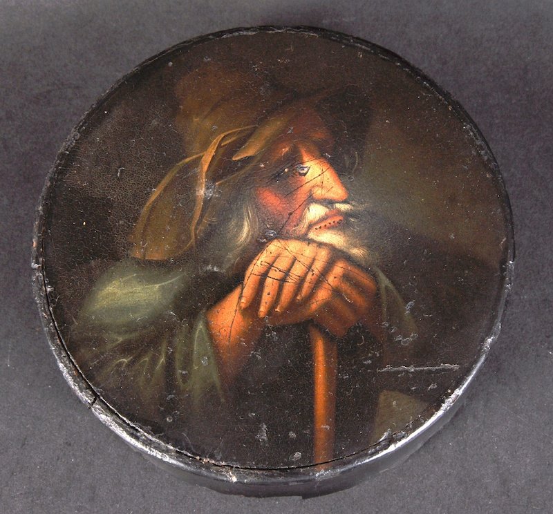 A 19TH CENTURY PAPIER MACHE CIRCULAR BOX AND COVER, 4.: A 19TH CENTURY PAPIER MACHE CIRCULAR BOX AND COVER, 4.75ins diameter, the lid painted with a old man resting on a stick.
