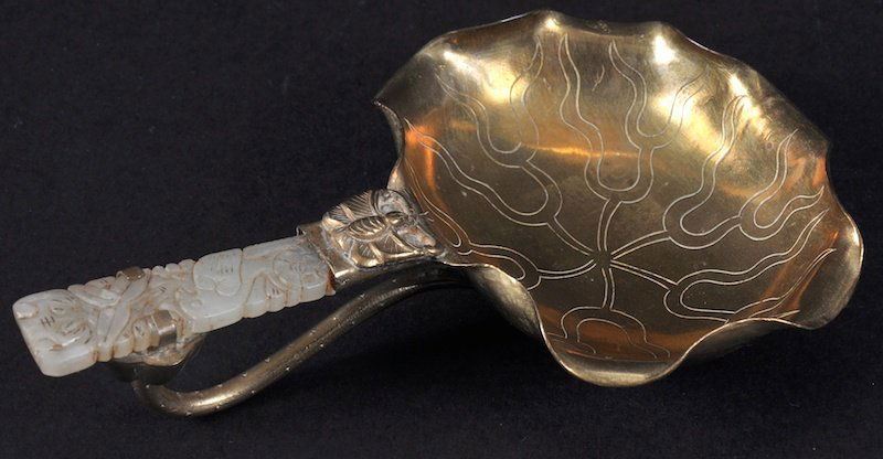 A 19TH CENTURY CHINESE BRASS HANDLED SPOON with white j: A 19TH CENTURY CHINESE BRASS HANDLED SPOON with white jade handle carved with birds and foliage. Good condition.55ins long.