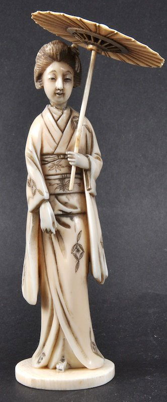A LATE 19TH CENTURY JAPANESE MEIJI PERIOD IVORY OKIMONO: A LATE 19TH CENTURY JAPANESE MEIJI PERIOD IVORY OKIMONO modelled holding a parasol. Head re attached. Ivory 5.25ins high.