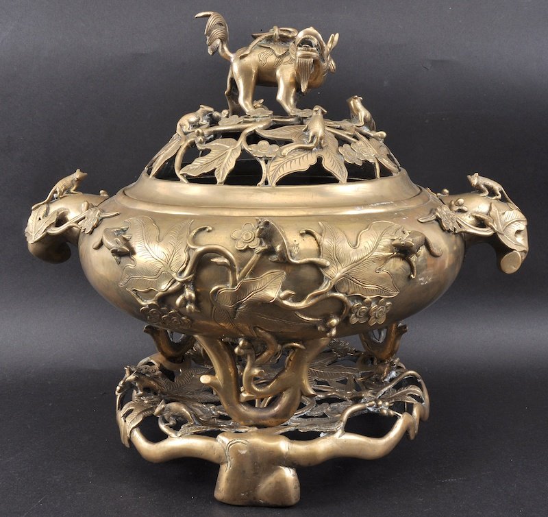 A RARE 19TH CENTURY CHINESE BRONZE CENSER AND COVER of: A RARE 19TH CENTURY CHINESE BRONZE CENSER AND COVER of large proportions, modelled upon a naturalistic base, with kylin terminal. Few holes, faults. 1ft 8.5ins wide.