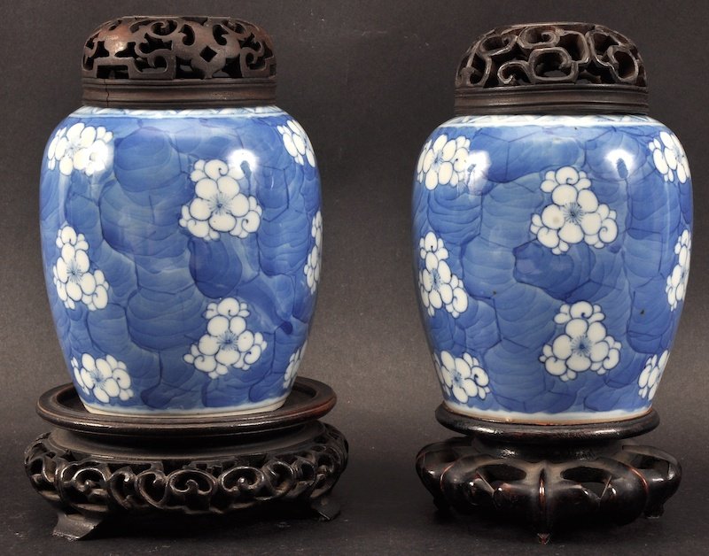 A MATCHED PAIR OF LATE 18TH CENTURY CHINESE BLUE AND WH: A MATCHED PAIR OF LATE 18TH CENTURY CHINESE BLUE AND WHITE GINGER JARS with wooden covers and bases, painted with prunus. Good condition. Jar 5ins high.