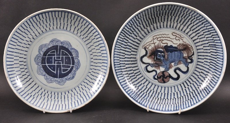 AN EARLY 19TH CENTURY CHINESE BLUE AND WHITE CIRCULAR D: AN EARLY 19TH CENTURY CHINESE BLUE AND WHITE CIRCULAR DISH painted with a central shishi dog, together with another dish. One rim repair, one with nick and hairline. 10.25ins diameter. (2)