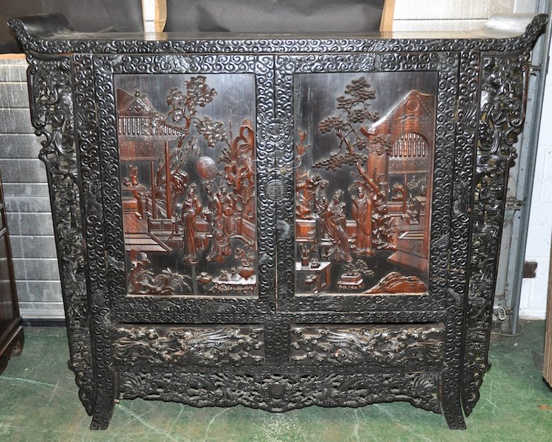 A FINE AND RARE CHINESE QING DYNASTY ZITAN WOOD CABINET: A FINE AND RARE CHINESE QING DYNASTY ZITAN WOOD CABINET of Imperial quality, exceptionally carved with figures standing within an elaborate garden, the body heavily carved with entwined dragons amongs