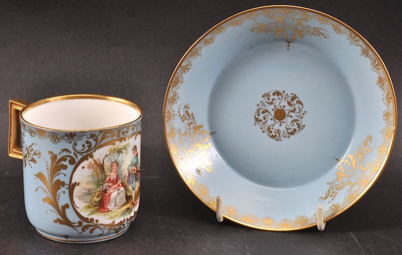 A 19TH CENTURY MEISSEN COFFEE CAN AND SAUCER painted wi: A 19TH CENTURY MEISSEN COFFEE CAN AND SAUCER painted with romantic panels.