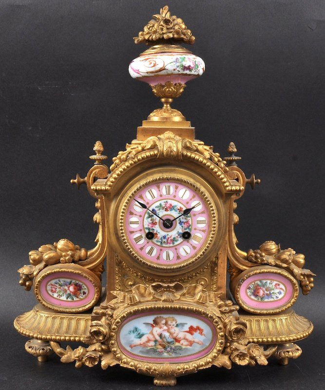 A 19th Century French Ormolu Mantle Clock Painted With: A 19TH CENTURY FRENCH ORMOLU MANTLE CLOCK painted with pink Sevres panels, urn finial and striking on a single bell. 15.5ins high.