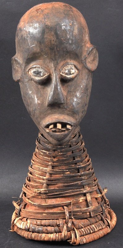 AN AFRICAN CARVED WOOD HIDE MOUNTED HEAD with cane work: AN AFRICAN CARVED WOOD HIDE MOUNTED HEAD with cane work base. 16ins high.
