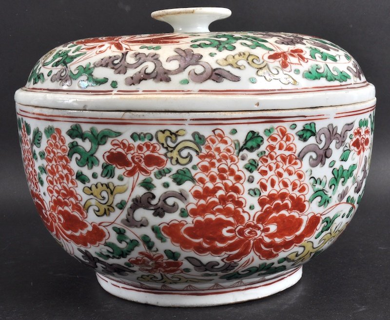 A 17TH CENTURY CHINESE WUCAI PORCELAIN JAR AND COVER: A 17TH CENTURY CHINESE WUCAI PORCELAIN JAR AND COVER Shunzi, painted with bold floral sprays under a red rim. Crack to base, chips to rim. 9.5ins diameter.