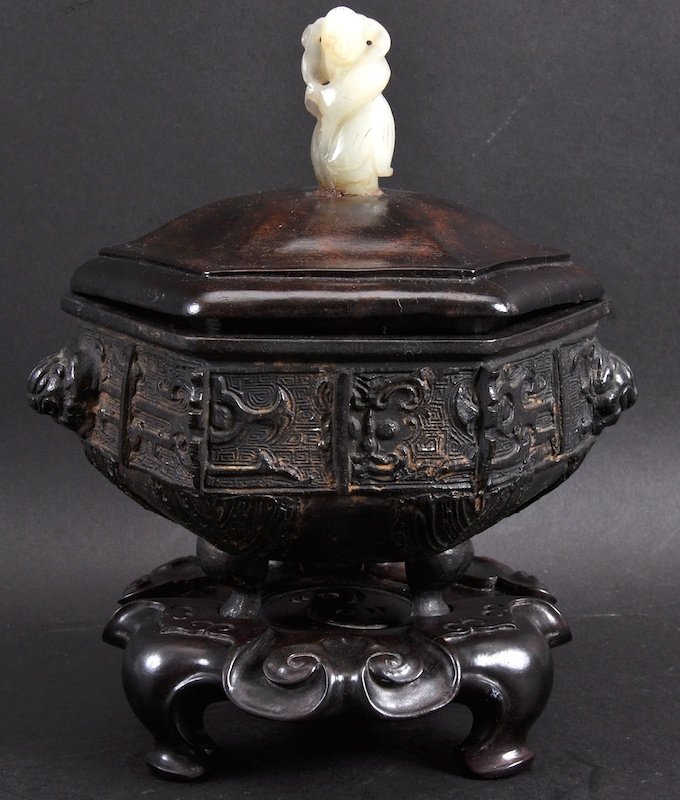 AN 18TH CENTURY CHINESE BRONZE TWIN HANDLED CENSER: AN 18TH CENTURY CHINESE BRONZE TWIN HANDLED CENSER Qianlong, with jade and hardwood cover, upon a fine hardwood base. Minor wear. 6.5ins wide.
