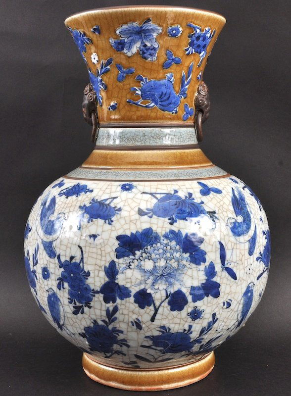 A 20TH CENTURY CHINESE BLUE AND WHITE CRACKLED GLAZED: A 20TH CENTURY CHINESE BLUE AND WHITE CRACKLED GLAZED VASE painted with birds and flowering vines. Good condition. 16ins high.