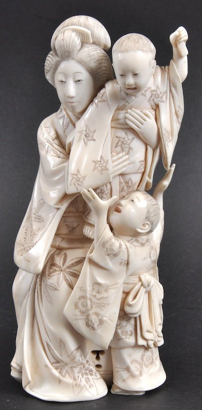AN EARLY 20TH CENTURY JAPANESE MEIJI PERIOD TOKYO: AN EARLY 20TH CENTURY JAPANESE MEIJI PERIOD TOKYO SCHOOL OKIMONO depicting a mother and two children. Signed. Lacking utensil from hand. 6ins high.