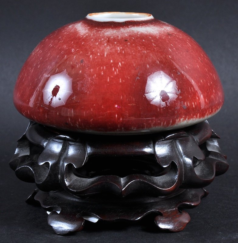A CHINESE FLAMBE GLAZED BRUSH WASHER probably late: A CHINESE FLAMBE GLAZED BRUSH WASHER probably late Qing, of graduated colour, upon a well carved hardwood base. Crazing. 4.25ins diameter.