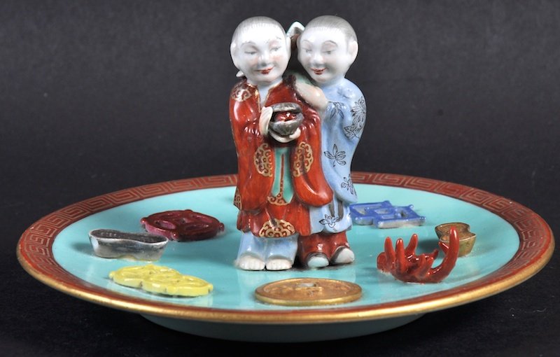 A LOVELY CHINESE QING DYNASTY PORCELAIN DISH bearing: A LOVELY CHINESE QING DYNASTY PORCELAIN DISH bearing Qianlong marks to base, with two young boys surrounded by coinage and motifs. 4.75ins wide.