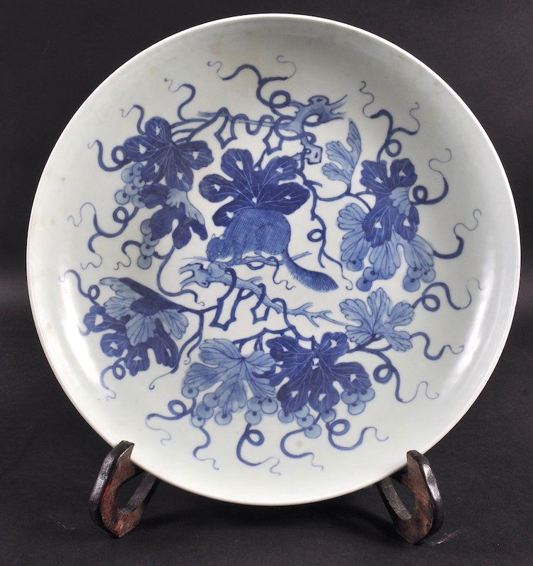 A CHINESE BLUE AND WHITE PORCELAIN DISH painted with a: A CHINESE BLUE AND WHITE PORCELAIN DISH painted with a squirrel amongst foliage. Good condition. 12ins diameter.