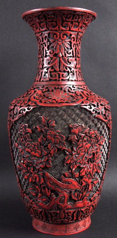 A CHINESE RED LACQUER MING STYLE VASE bearing Wanli: A CHINESE RED LACQUER MING STYLE VASE bearing Wanli marks to base, carved with flowers. Good condition. 14.5ins high.