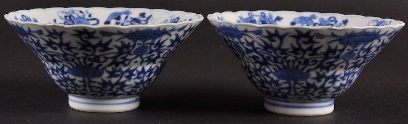 A PAIR OF 19TH CENTURY CHINESE BLUE AND WHITE SCALLOPED: A PAIR OF 19TH CENTURY CHINESE BLUE AND WHITE SCALLOPED TEABOWLS bearing Yongzheng marks to base, painted with scrolling foliage and bats. Minor fritting. 3.75ins diameter.