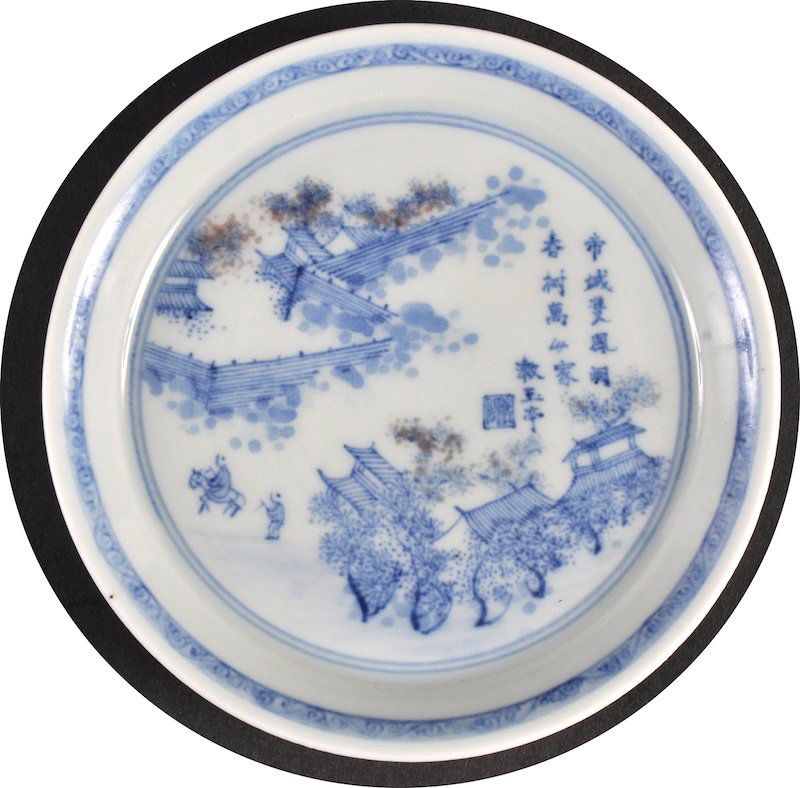 A CHINESE BLUE AND WHITE CIRCULAR SAUCER bearing unusua: A CHINESE BLUE AND WHITE CIRCULAR SAUCER bearing unusual Kangxi marks to base, painted with landscapes. 4.25ins diameter.