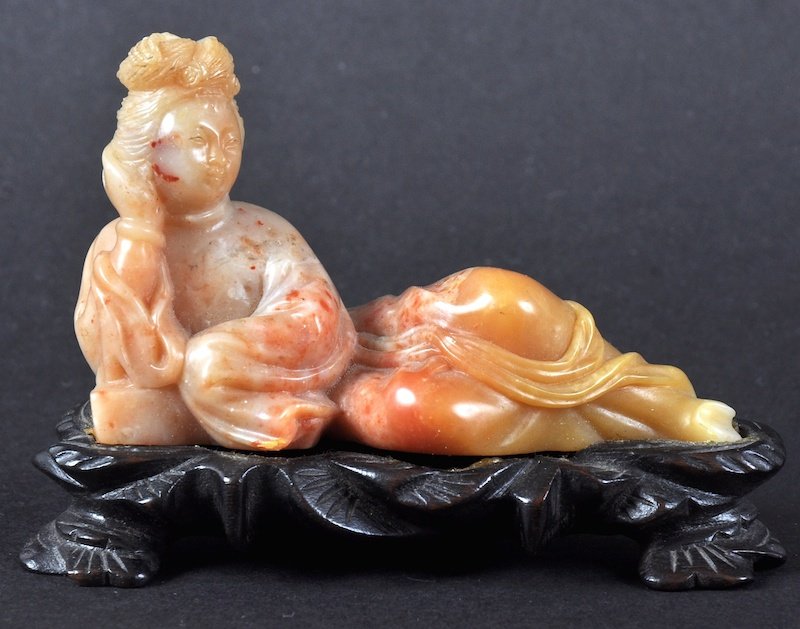 A 19TH/20TH CENTURY CHINESE CARVED SOAPSTONE FIGURE OF: A 19TH/20TH CENTURY CHINESE CARVED SOAPSTONE FIGURE OF GUANYIN modelled reclining. Good condition. 3.5ins wide.
